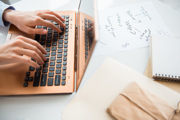 Poster - Top view close up businesswoman hands typing in keyboard of digital device near papers with information while locating on desk. Labor concept