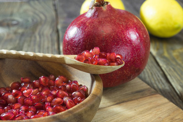 Pomegranate grains in a wooden bowl closeup