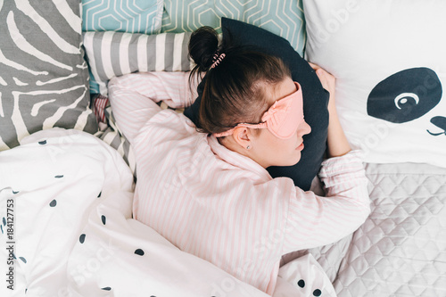 Top View Of A Young Woman Sleeping On A Pillow Sleeping Mask On A