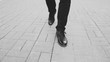 © silverkblack - Closeup view businessman in shoes walking ahead sidewalk at street