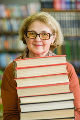 Wall Mural - Happy senior woman with books in library