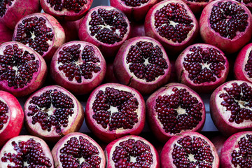 Wall Mural - Background of ripe juicy pomegranates shot close-up