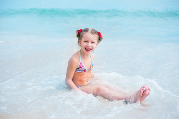 happy little girl swims in the sea, rejoices and plays
