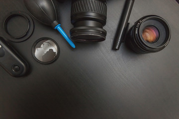 Sticker - top view of work space photographer with dslr camera system, camera cleaning kit and camera accessory on black table background with copy space