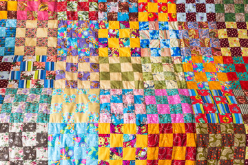 hobby, art, inspiration concept. close-up on delicately stitched old blanket with colored patchwork 