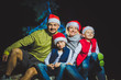 © Michael - Portrait of friendly family in Santa caps looking at camera on Christmas evening