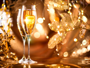 Wall Mural - Christmas celebration. Flutes with sparkling champagne over holiday glowing background