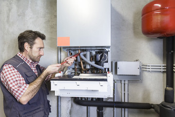 plumber repairing a condensing boiler