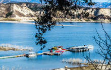 Long Wooden Pier With Boats In California's Lake Cachuma With San Rafael Mountains In The Distance