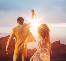 Ambitious Couple Looking At The Sunset With A Victorious Gesture
