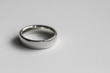 Silver metal wedding ring shot against a white background.