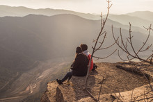 Couple Sitting On High Mountain Peak Watching The Beautiful And Surreal Wilderness Landscape In Front Of You In Siurana