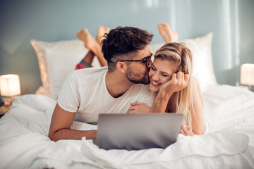 Wall Mural - Young loving couple in the bed