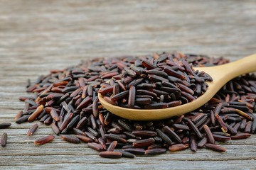 Wall Mural - Riceberry in wooden spoon on rustic wood background.