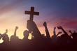 Silhouette hand holding christian cross