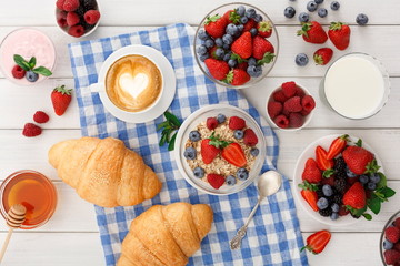 Continental breakfast with croissants and berries on checkered cloth