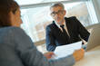 © goodluz - Woman in banker's office signing financial loan for project