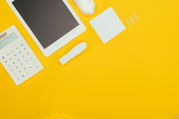 Poster - top view of digital tablet with blank screen, calculator and office supplies isolated on yellow