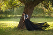 © kharchenkoirina - Exquisite lady in a vintage dress for walking with a horse. A beautiful rider stands under a tree. Artistic Photography