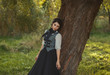 © kharchenkoirina - Exquisite lady in a vintage dress for walking with a horse. A beautiful rider stands under a tree. Artistic Photography