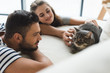 © LIGHTFIELD STUDIOS - happy young couple petting cat while he sitting on couch