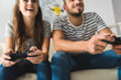 © LIGHTFIELD STUDIOS - close-up shot of young couple playing games with gamepads at home