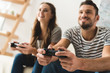 © LIGHTFIELD STUDIOS - smiling young couple playing games with gamepads at home