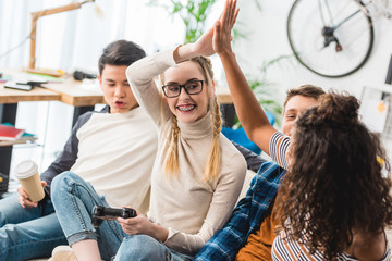 girls giving high five for winning boys in video game