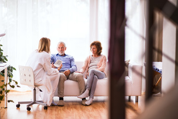 Wall Mural - Female doctor checking blood pressure of senior man.