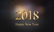 2018 card with golden, glowing, sparkle Happy New Year text on dark grey background with blurry, colorful lights. New Year's eve illustration