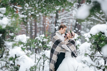 Romatic couple in love the plaid looks at each other in winter forest. Artwork. Wedding