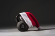 © Paul - A black Kettlebell with a red and white Santa hat on a plain black background