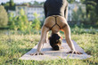 © Arno Images - Young Japanese woman practicing yoga exercises near a river in a summer day in the city