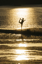 Young Japanese Woman Practicing Yoga Exercises Near A River In A Summer Day In The City At Sunset