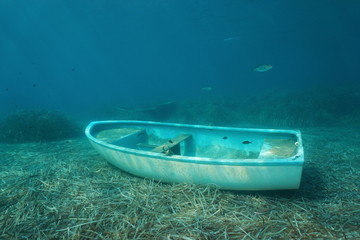 Wall Mural - Underwater a small boat sunken on the seabed with leaves of Neptune grass and some fish, Mediterranean sea, Catalonia, Costa Brava, Spain
