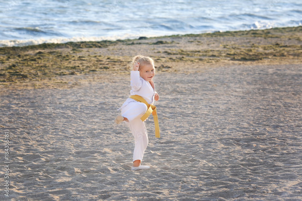 Little girl practicing karate outdoors