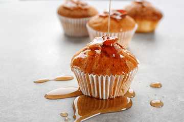 Poster - Pouring maple syrup onto tasty bacon muffin on table