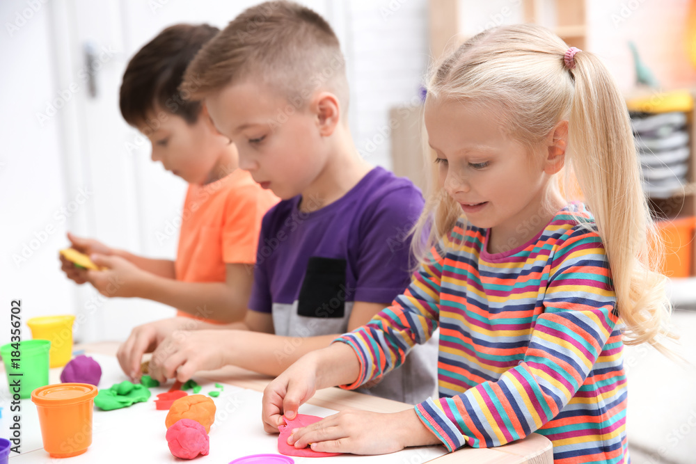 Little children engaged in playdough modeling at daycare