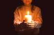 © Africa Studio - Little girl holding burning candle in darkness