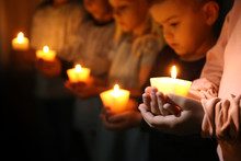 Little Children Holding Burning Candles In Darkness