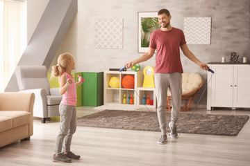 Sticker - Cute girl and her father jumping rope at home