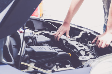 Check the condition of the car engine, repair or maintenance concept. Professional car mechanic fixing a car engine in auto repair workshop service. Selective focus.