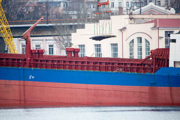 Vessel dry cargo on loading, unloading in port. Bulker in port. port crane loads bulk cargo at bulk carrier