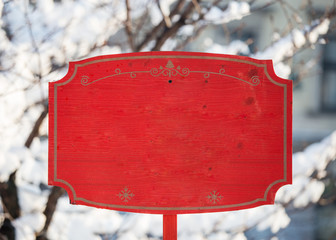 Red holiday Christmas wooden sign mockup empty placeholder entrance exit New Year Santa holiday market in the park during winter snow trees