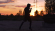 © silverkblack - Silhouette of young man boxer training for kicking on sunset at city park