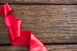 Red ribbon on wooden table