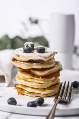 Wall Mural - Pile of american pancakes with blueberries and powdered sugar.