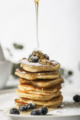 Wall Mural - Pancake piles with blueberries on the top, maple leaf syrup is pouring on it.