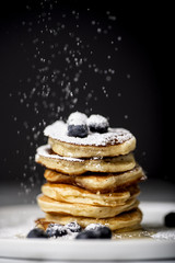 Wall Mural - Pancake pile with blueberries, sifting powdered sugar on the top of it.