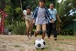 © wavebreak3 - Happy family playing soccer in yard